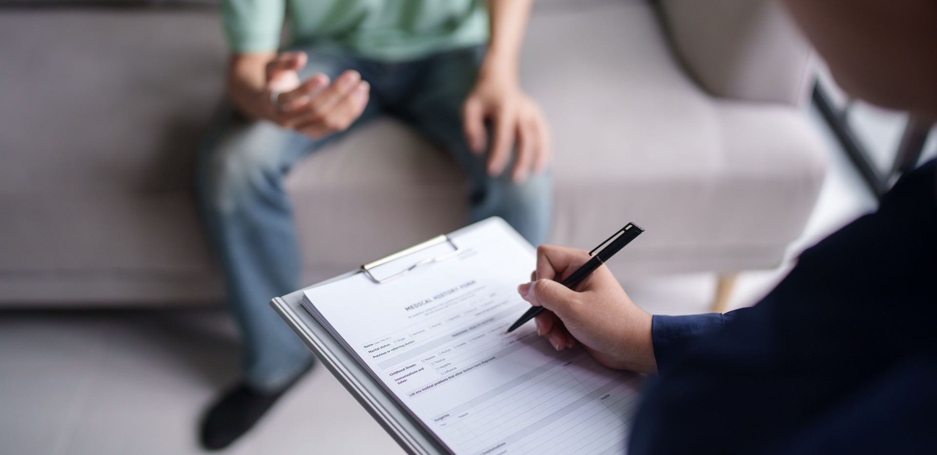 sad male sitting onÂ sofa Patient discussing mental health issues with psychologist.Â depressed asian man mental health treatment